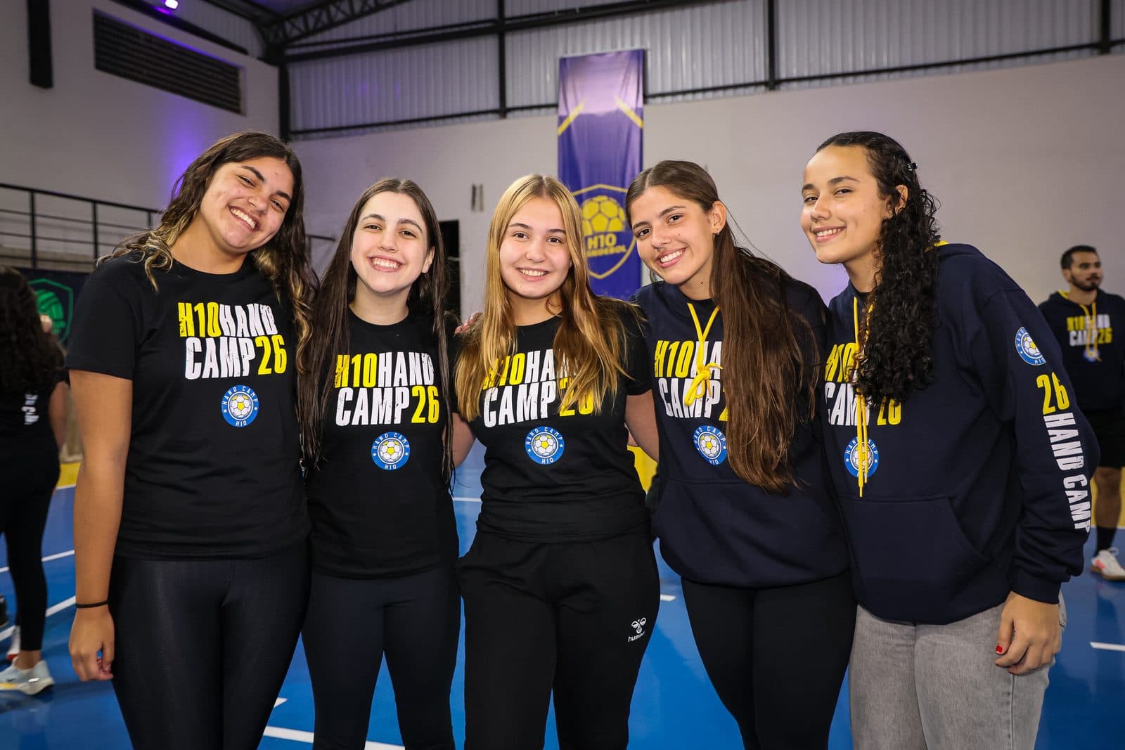 Grupo de meninas de moletom H10 Hand Camp sorrindo juntas no ginasio