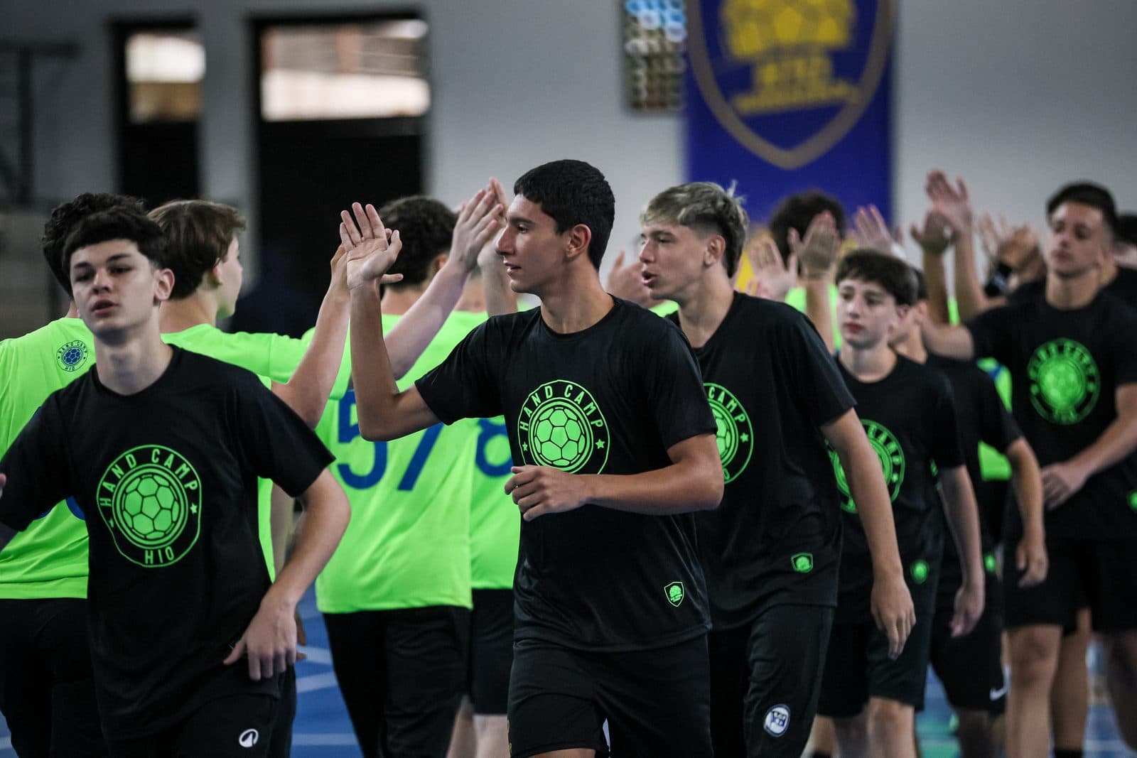 Fila de acampantes cumprimentando de maos altas antes do treino